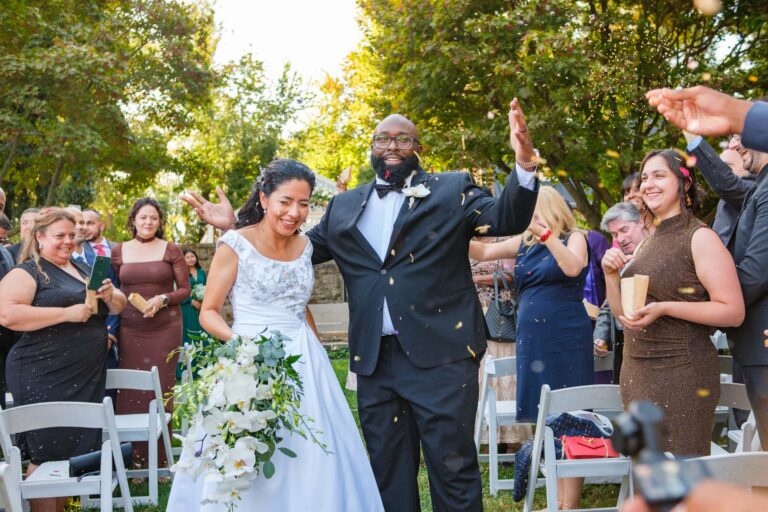 Andrea and Omar celebrating as they walk back up the aisle at Historic Shady Lane in York, PA