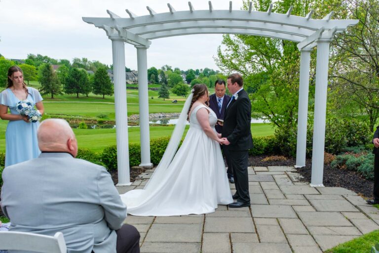 Dan and Maddie under the white pergola at their Heritage Hills outdoor ceremony