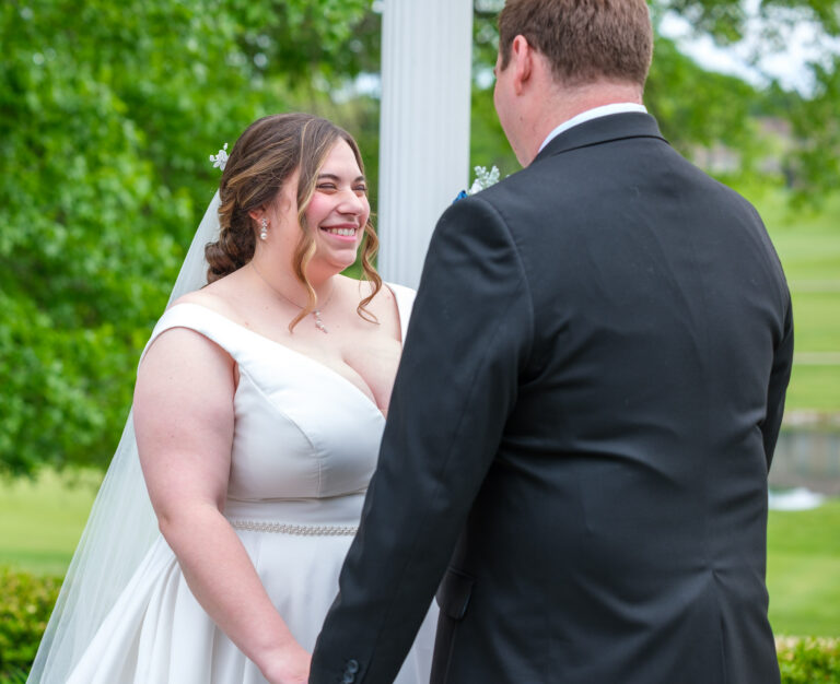 Maddie smiling at Dan during their outdoor ceremony at Heritage Hills Golf Resort