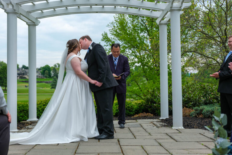 Dan and Maddie's first kiss at their outdoor ceremony at Heritage Hills Golf Resort
