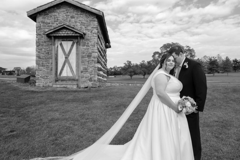 Black and white portrait of Dan and Maddie by the stone springhouse at Heritage Hills Golf Resort