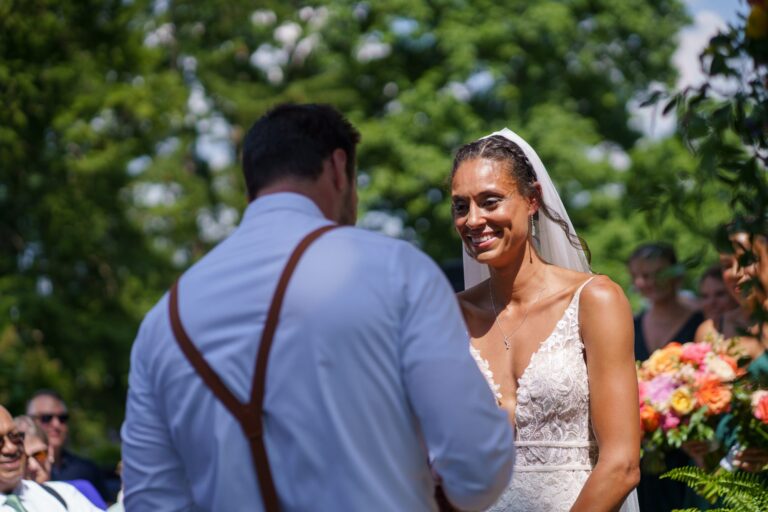 Jess and Jake facing each other during their outdoor ceremony at Rockfield Manor